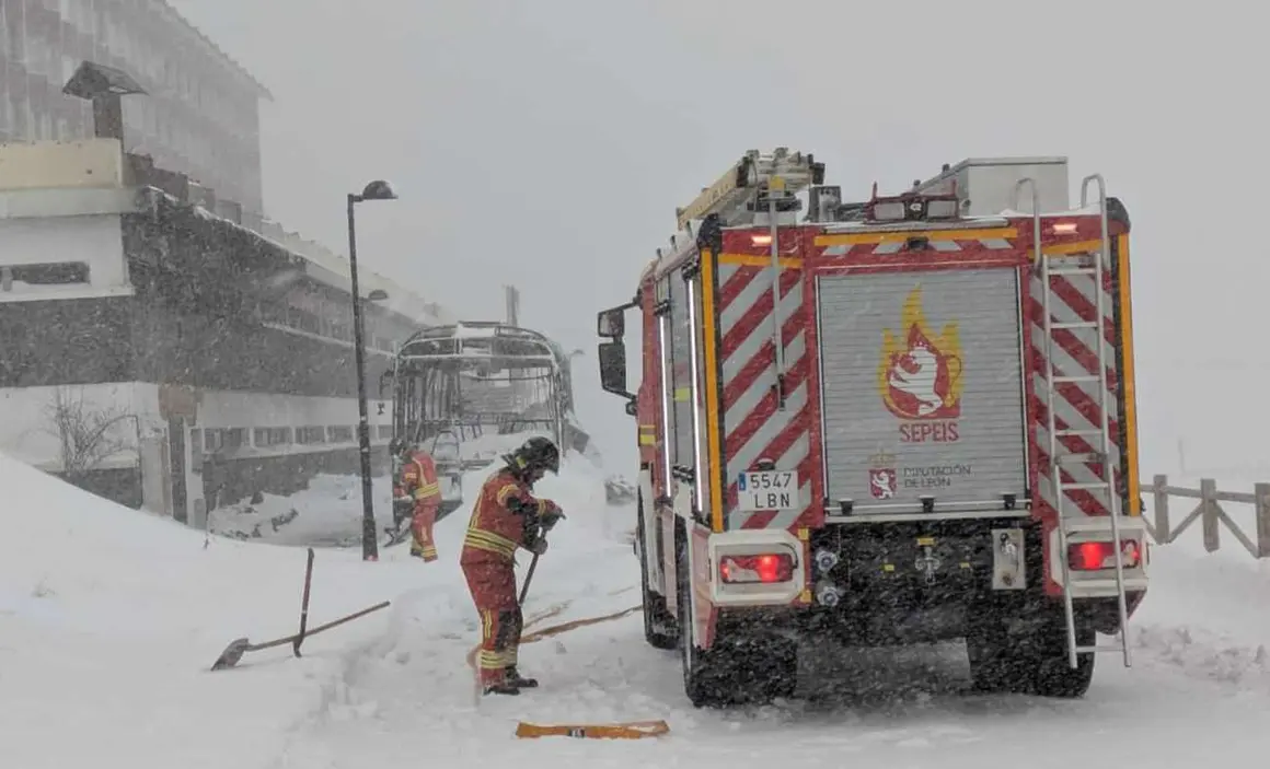 El incendio durante la madrugada de un autobús en un estacionamiento próximo a la estación invernal de San Isidro ha tenido que ser sofocado este jueves con el uso de una 'fresadora' quitanieves hasta la llegada de Bomberos Diputación, complicada por la tormenta 'Ivo' sobre la zona. Fotos: Sepeis