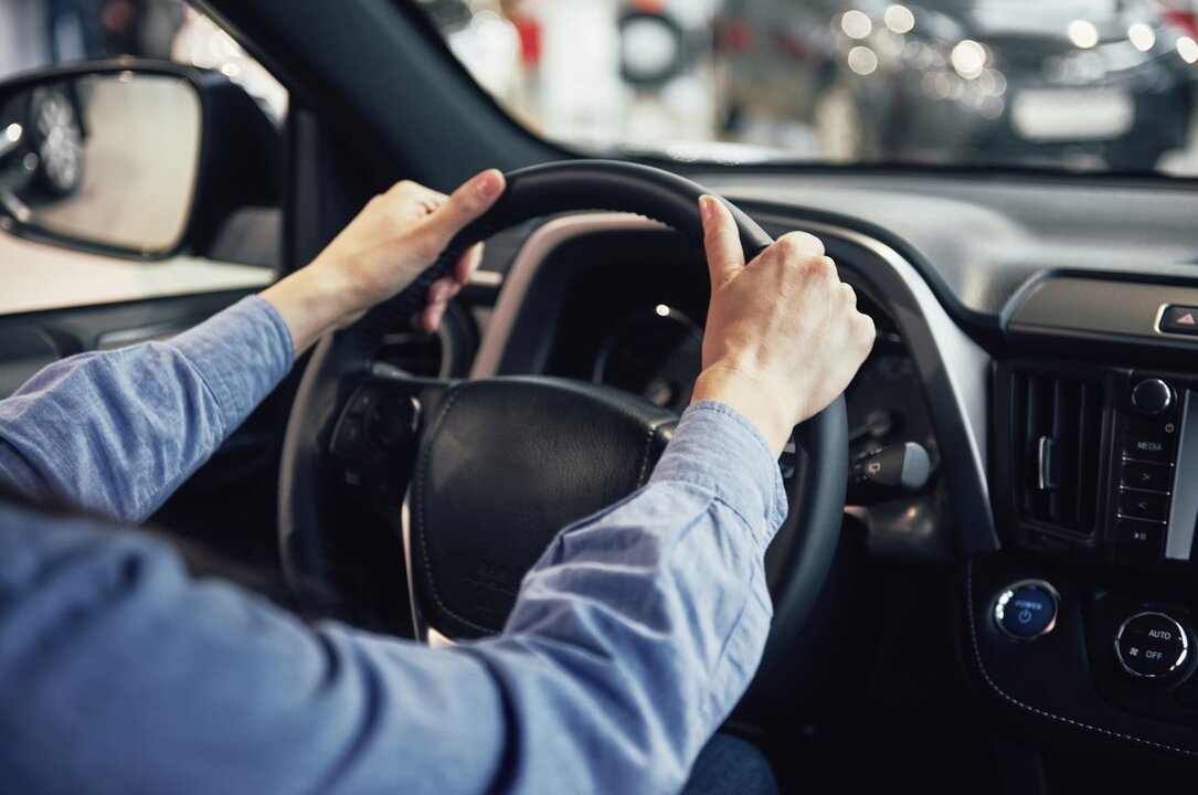 auto business, car sale, consumerism and people concept - happy woman taking car key from dealer in auto show or salon.