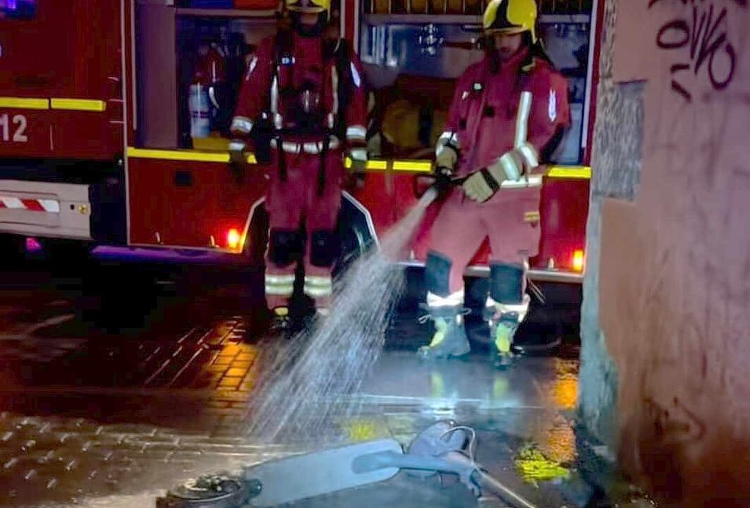 Efectivos de Bomberos León sofocando las llamas del patinete.