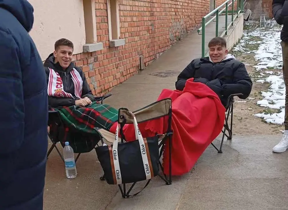 Dos jóvenes aficionados de la Cultural esperan, durante horas, a las puertas de la taquilla de La Albuera.