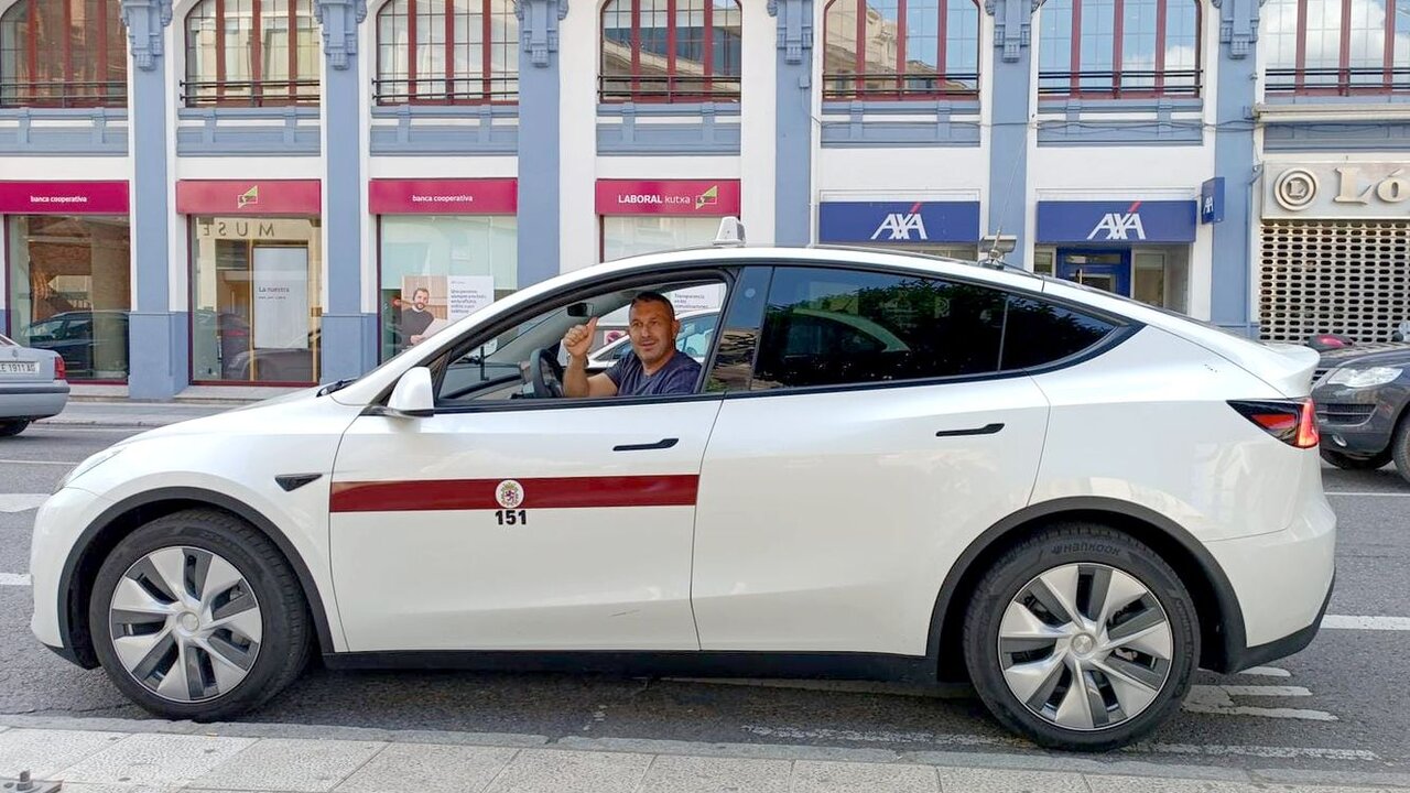 Un taxista con su vehículo eléctrico, en su parada del centro de la ciudad.