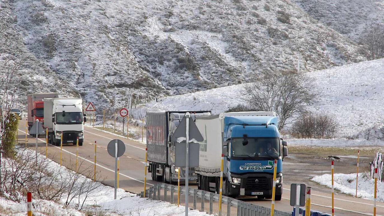 Vehículos pesados este viernes en el Puerto de Pajares, con nieve en las últimas horas. Foto: Peio García