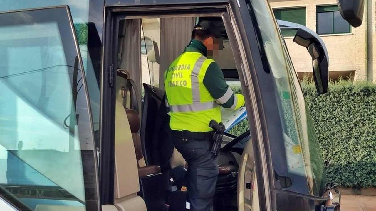 Un guardia civil realiza el control de un vehículo de transporte escolar.