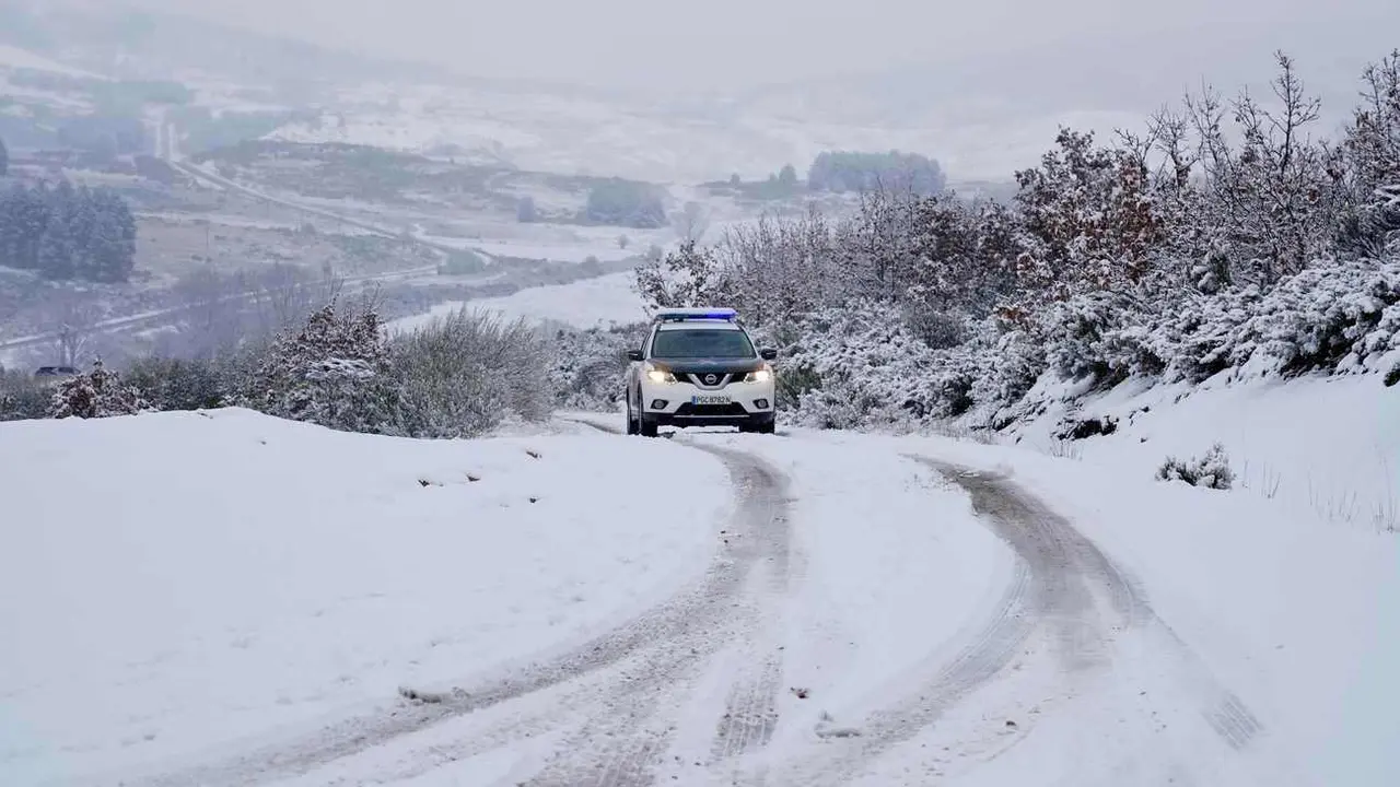 Un vehículo de la Guardia Civil circula sobre una carretera helada.