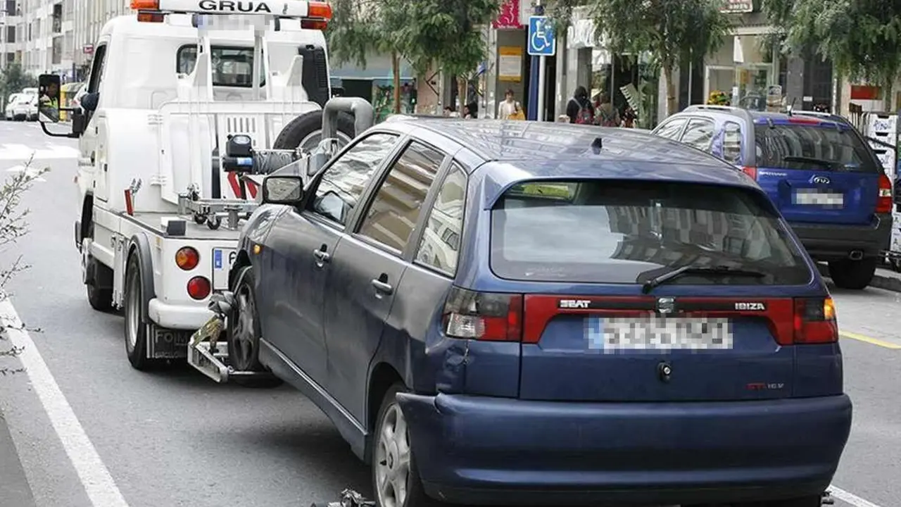 Imagen de una grúa retirando un vehículo al depósito municipal.