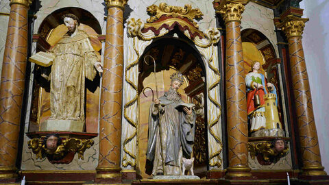 El historiador bembibrense, Manuel Olano, junto al retablo del santuario del Ecce-Homo de Bembibre, que custodia las imágenes del siglo XVI de San Antonio, y San Francisco, de la antigua Ermita de San Antonio y la talla de Santa Bárbara, del siglo XIX. Fotos: César Sánchez