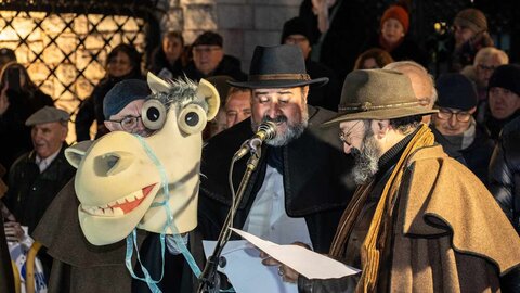 Decenas de leoneses se citan en la Plaza de San Marcelo, ante el edificio de Botines, para pedir al santo por León en medio de una celebración con chocolate y orujo. El escritor Juan Pedro Aparicio ha actuado como mantenedor. Fotos: Nael Blanco | Asociación Cultural San Francisco 'El Real' Extramuros