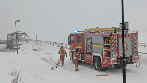 El incendio durante la madrugada de un autobús en un estacionamiento próximo a la estación invernal de San Isidro ha tenido que ser sofocado este jueves con el uso de una 'fresadora' quitanieves hasta la llegada de Bomberos Diputación, complicada por la tormenta 'Ivo' sobre la zona. Fotos: Sepeis