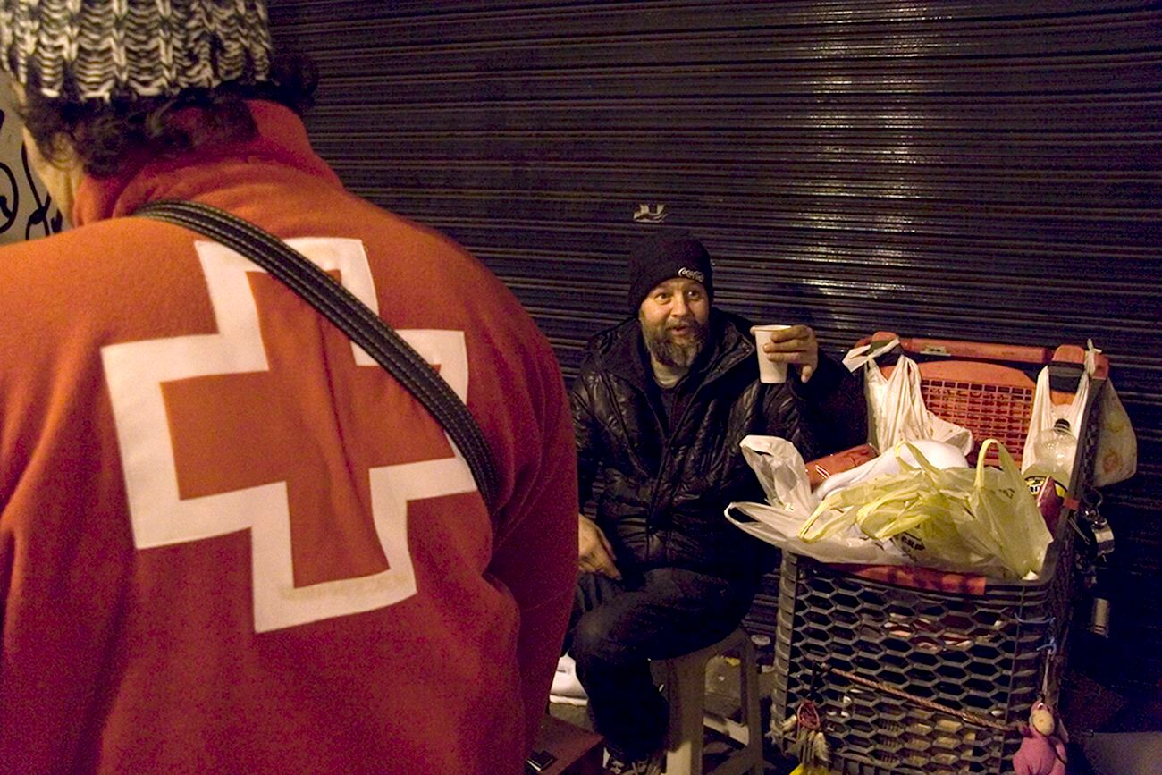 Personal de Cruz Roja atendiendo a una persona sin hogar en León capital.